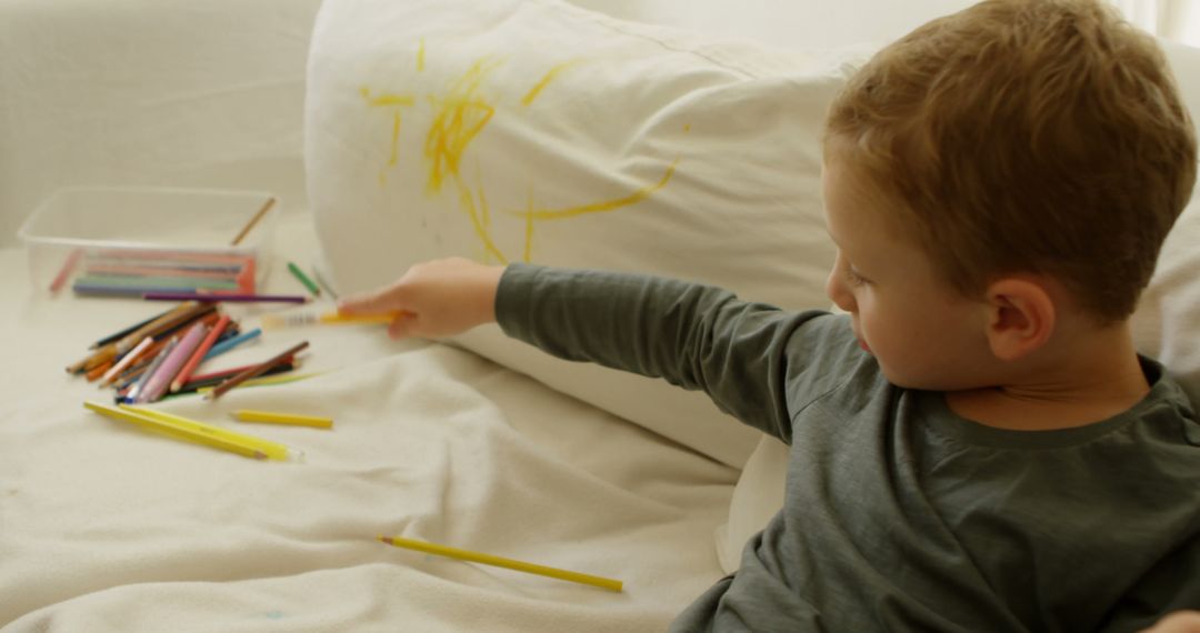 Young Boy Drawing with Colored Pencils on Couch - Free Images, Stock Photos and Pictures on Pikwizard.com