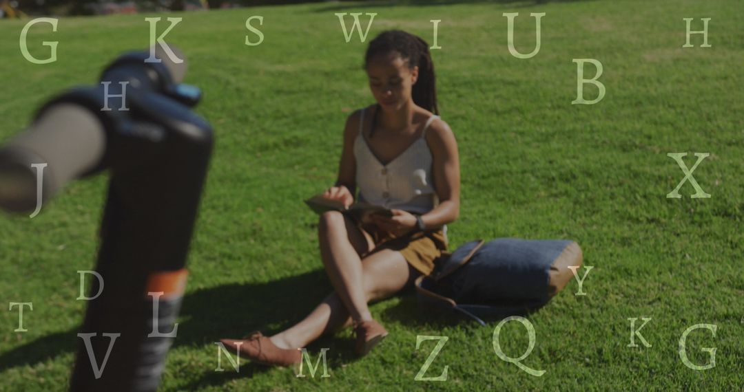 Woman Reading on Grass Near Scooter with Overlayed Letters