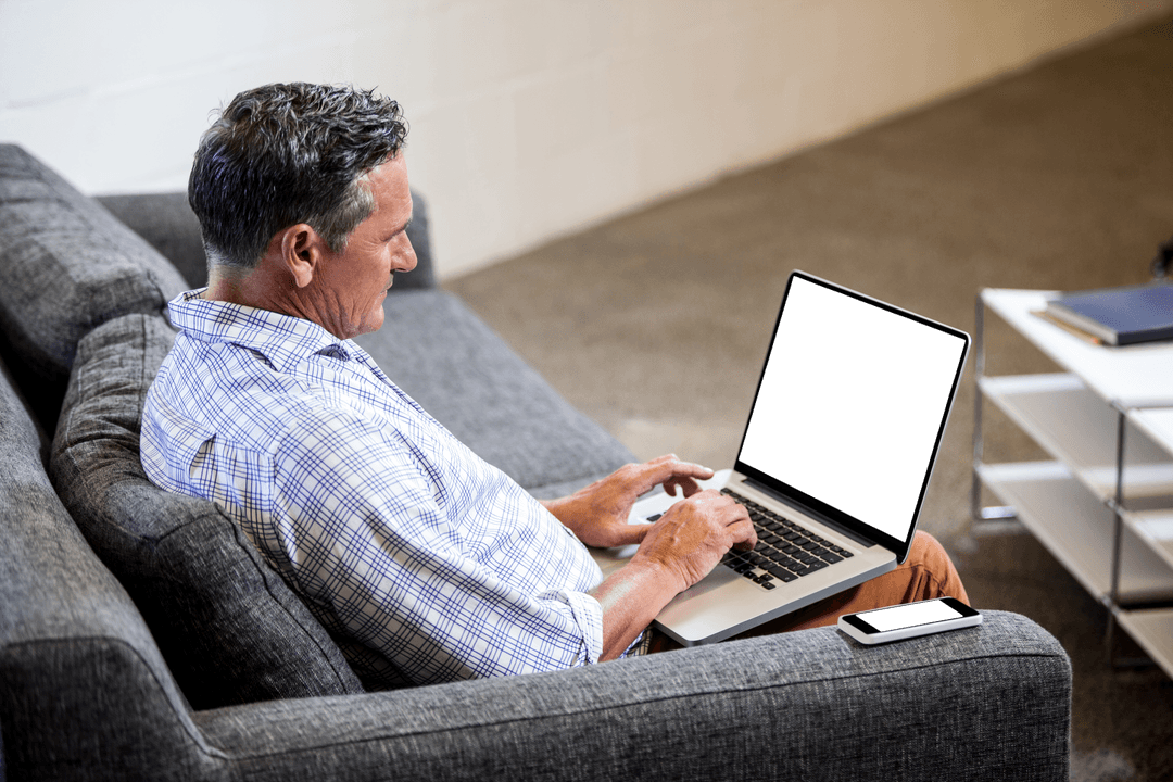Mature Man Typing on Laptop in Transparent Office Setting