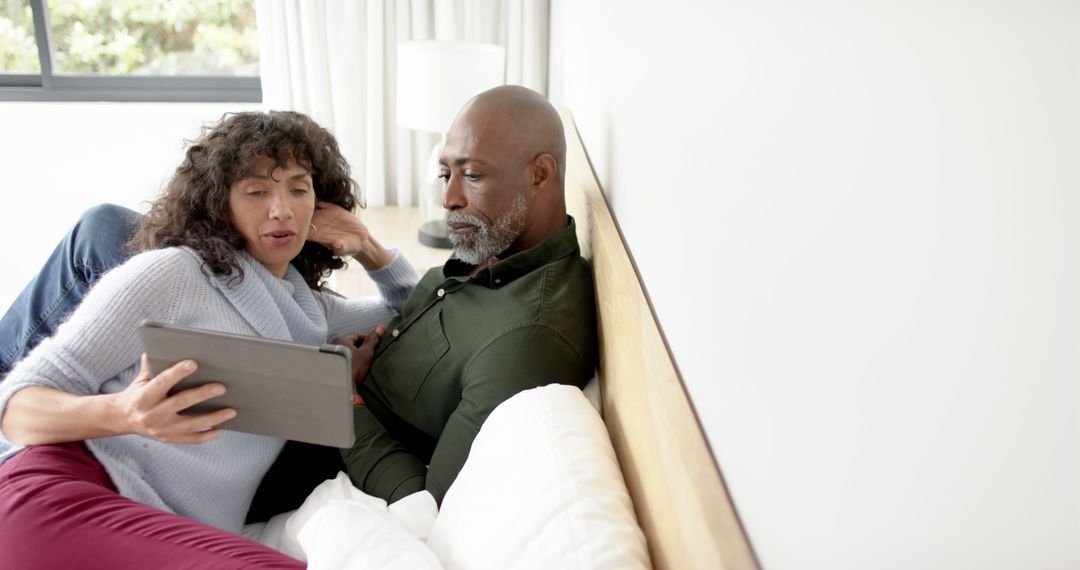 Mature Couple Enjoying Quality Time Using Tablet in Modern Home