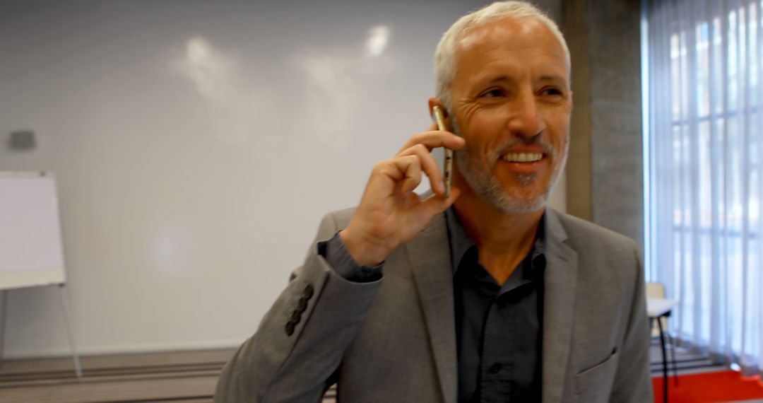 Confident Businessman Having Phone Call in Office Conference Room - Free Images, Stock Photos and Pictures on Pikwizard.com