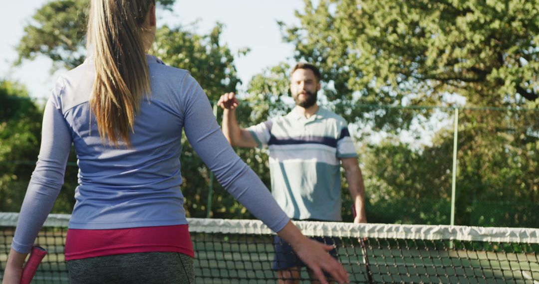 Couple Embracing on Outdoor Tennis Court During Daylight - Free Images, Stock Photos and Pictures on Pikwizard.com