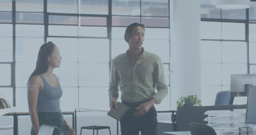 Colleagues Collaborating in Bright Open-Plan Office Discussing Project with Tablet