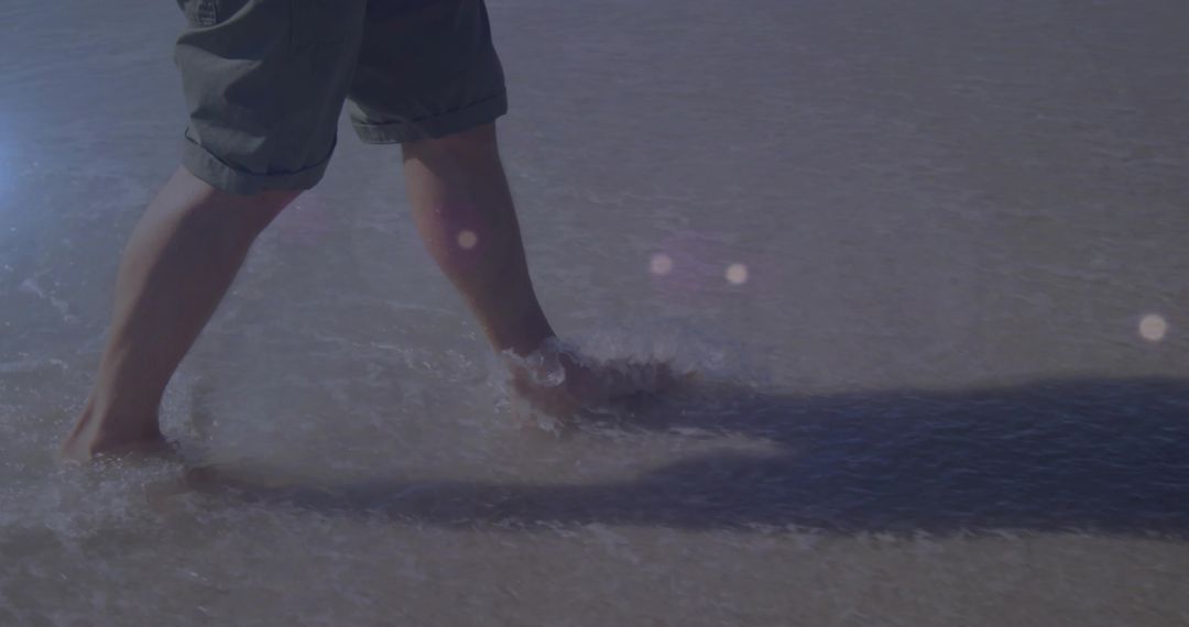 Man Wading Through Shallow Water on Beach