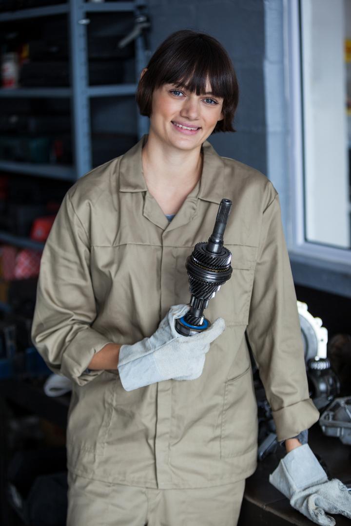 Portrait of female mechanic holding an car parts - Free Images, Stock Photos and Pictures on Pikwizard.com