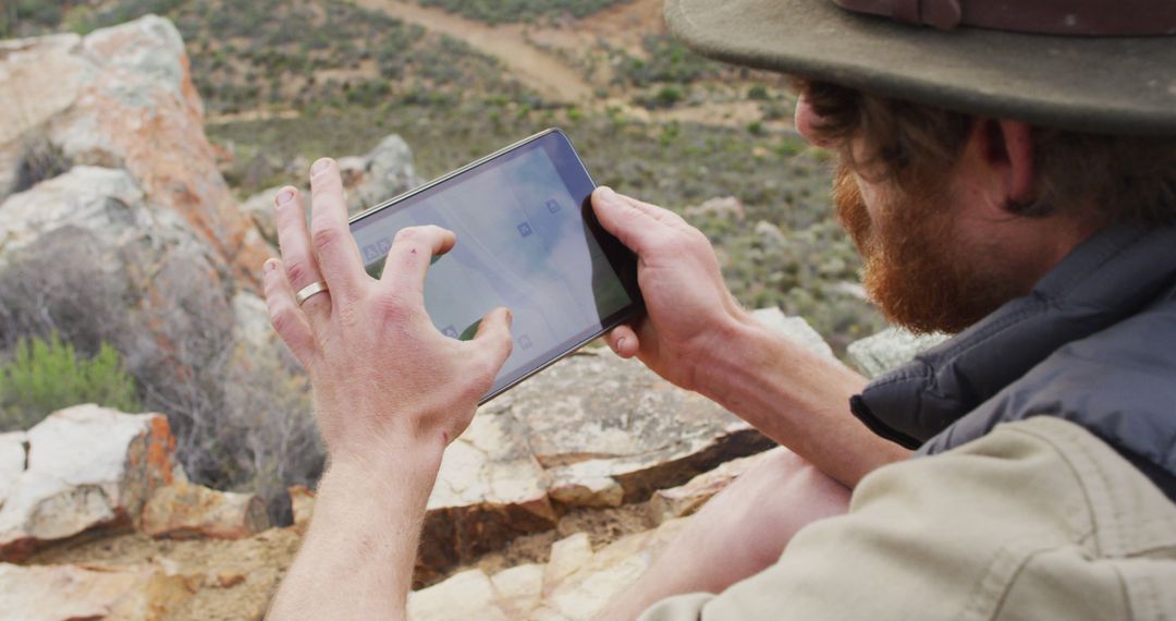 Explorer Navigating on Tablet in Rugged Outdoors Setting - Free Images, Stock Photos and Pictures on Pikwizard.com