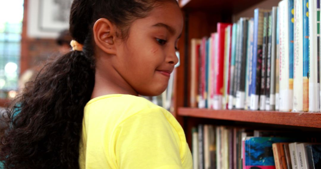 Young Girl Browsing Bookshelf in Library - Free Images, Stock Photos and Pictures on Pikwizard.com