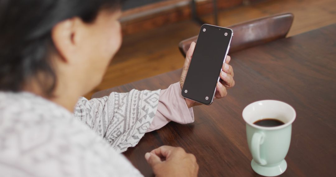 Woman Using Smartphone at Wooden Table with Coffee Mug - Free Images, Stock Photos and Pictures on Pikwizard.com