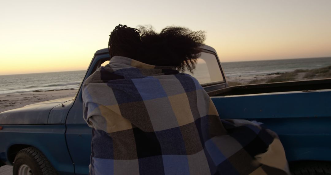 Woman Enjoying Ocean Sunset in Warm Blanket by Vintage Truck - Free Images, Stock Photos and Pictures on Pikwizard.com