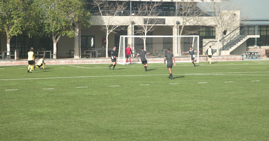 Competitive Soccer Match Highlighting Teamwork and Strategy on Green Field