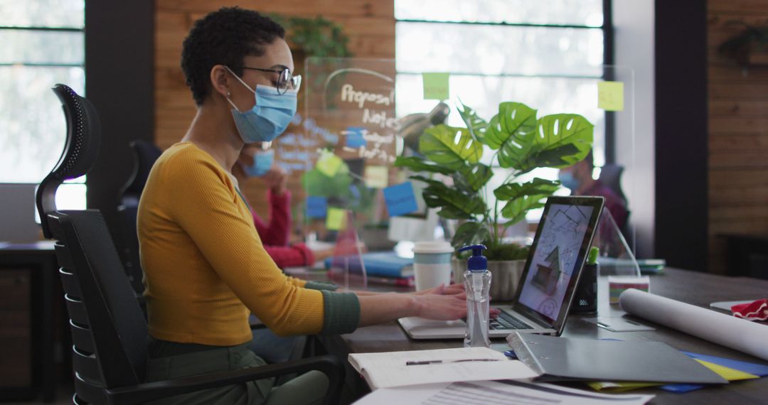 Focused Professional Team Member Collaborating in Modern Office Wearing Protective Mask - Free Images, Stock Photos and Pictures on Pikwizard.com