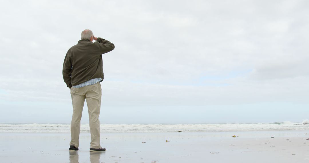 Senior Man Contemplating at the Beach on Overcast Day - Free Images, Stock Photos and Pictures on Pikwizard.com