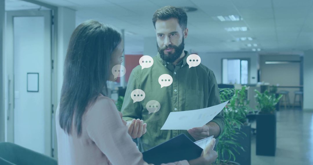 Colleagues Discussing Documents in Modern Open-Plan Office