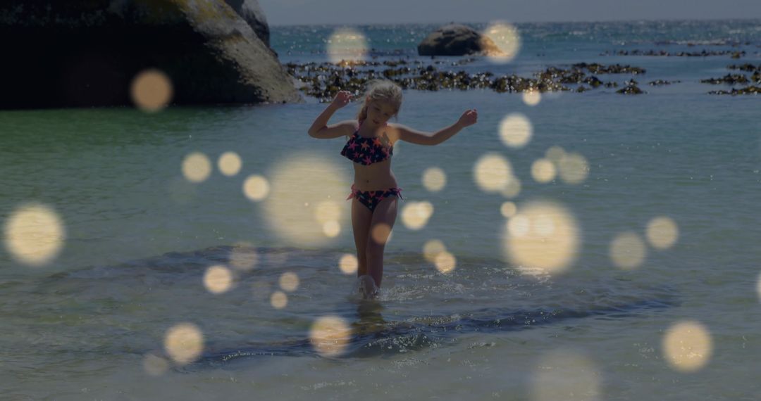 Child Wading in Rocky Cove Wearing Star Print Swimsuit