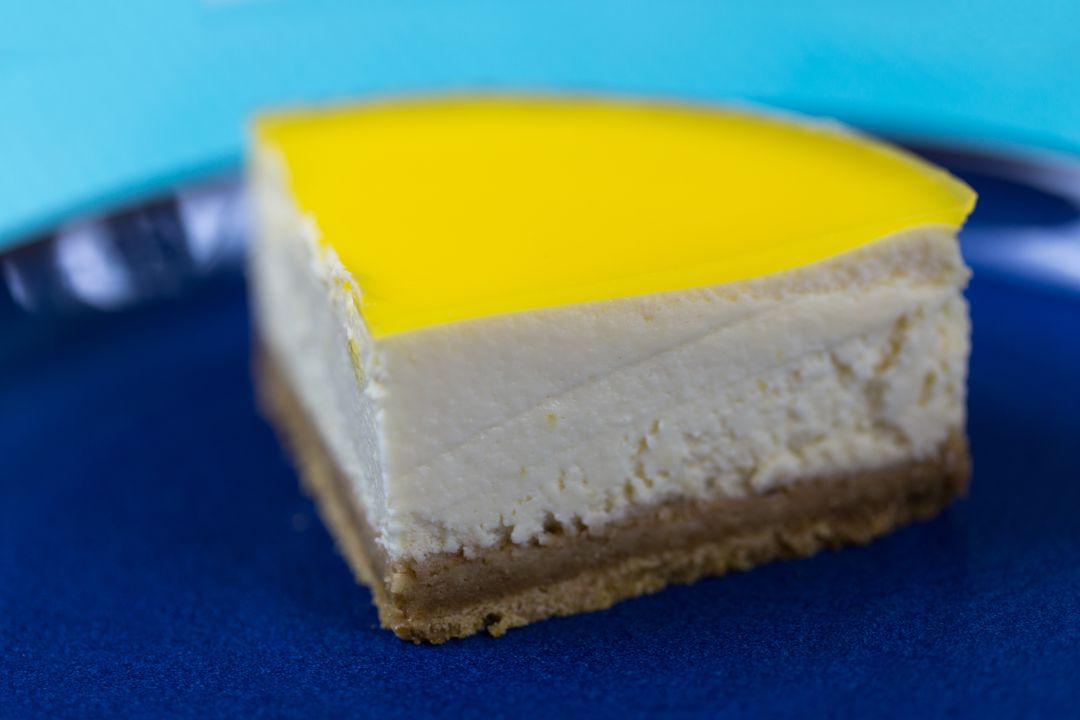 Refreshing Lemon-Topped Cheesecake Slice on Blue Plate