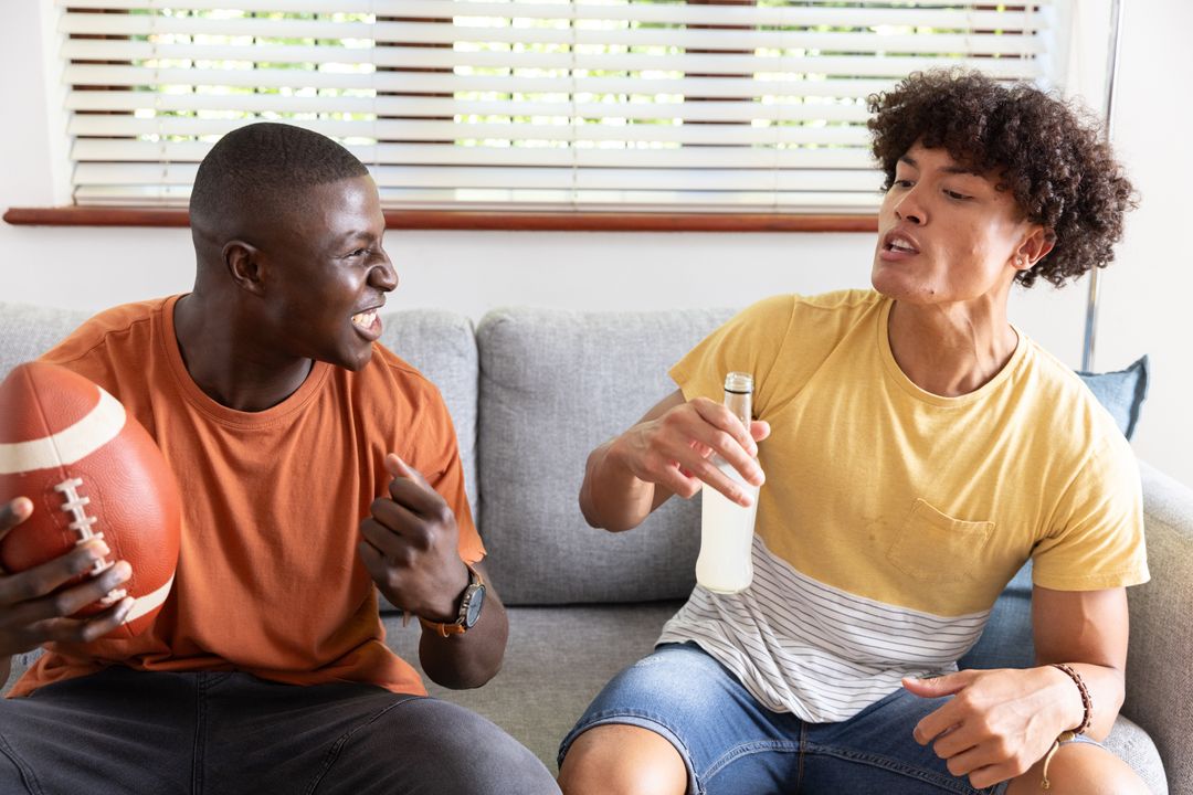 Diverse Male Friends Enjoying Relaxing Time with Football and Drink