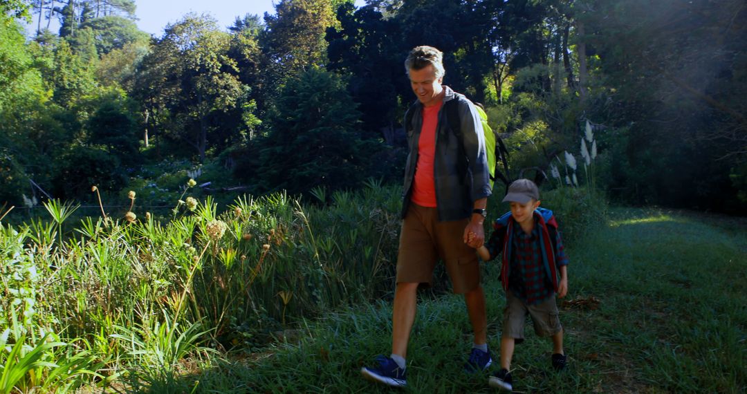 Father and son hiking through lush forest trail - Free Images, Stock Photos and Pictures on Pikwizard.com