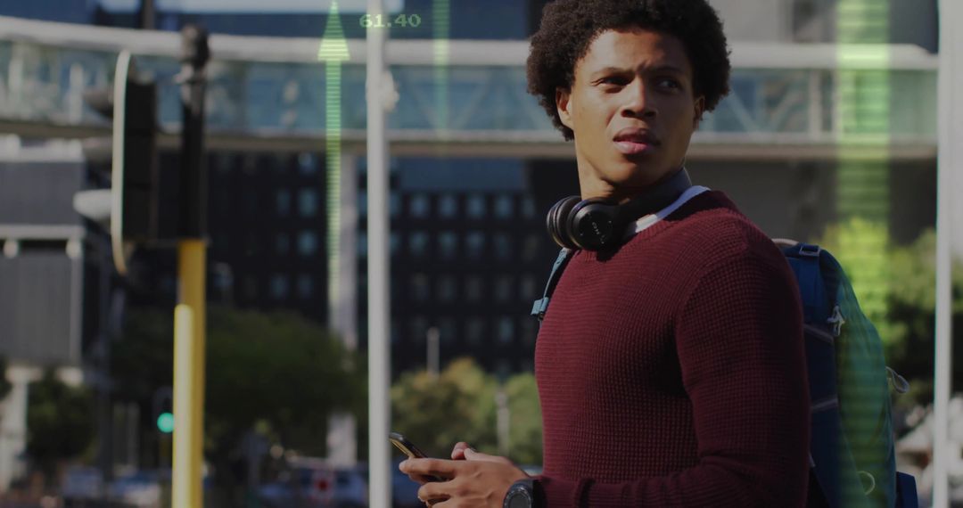 Young Man With Smartphone Standing in City Street Intersection