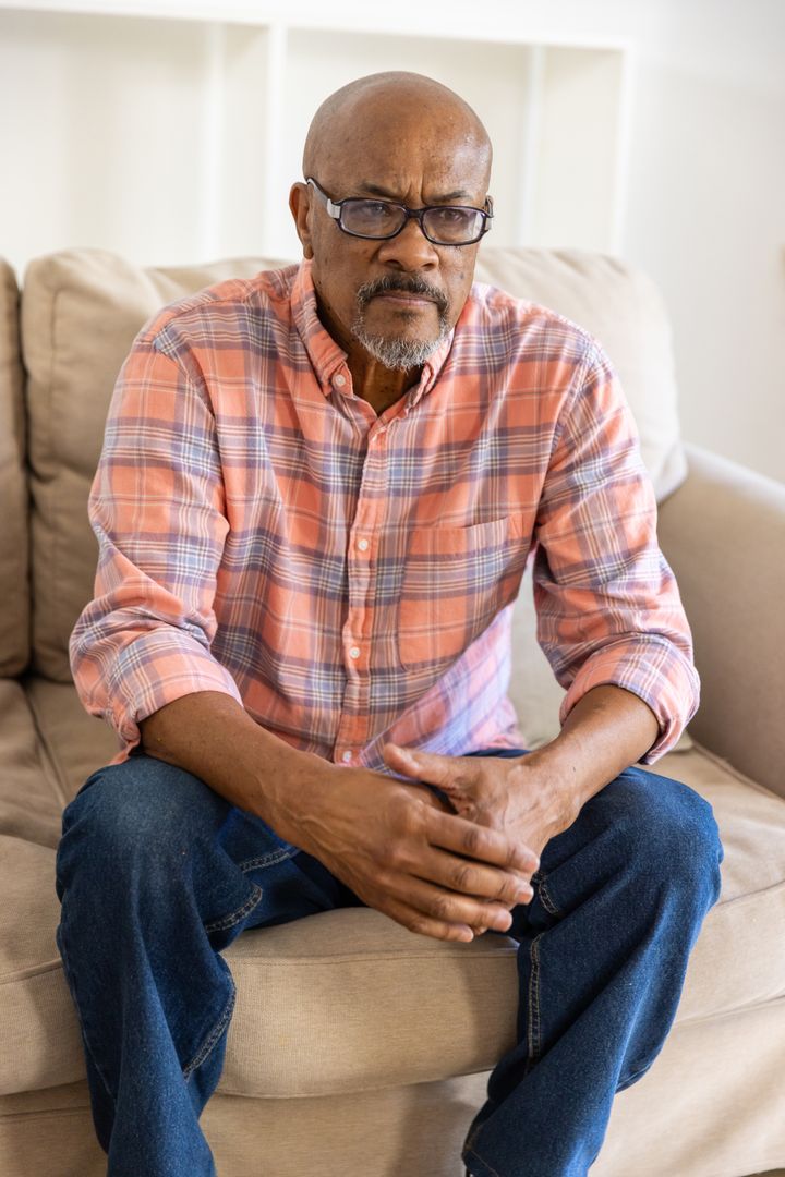 Introspective Senior Man Relaxing on Sofa at Home