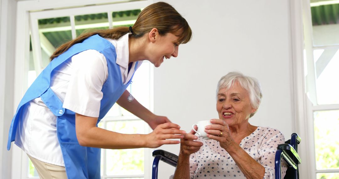 Caregiver Assisting Elderly Woman in Wheelchair with Drink - Free Images, Stock Photos and Pictures on Pikwizard.com