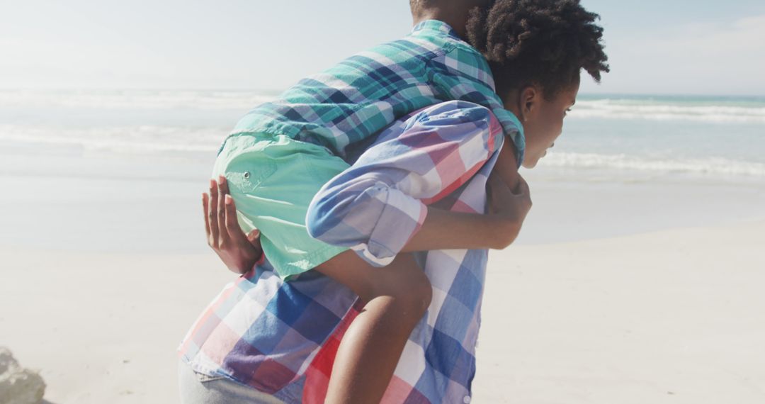 Mother Giving Playful Piggyback Ride to Her Son on Beach - Free Images, Stock Photos and Pictures on Pikwizard.com