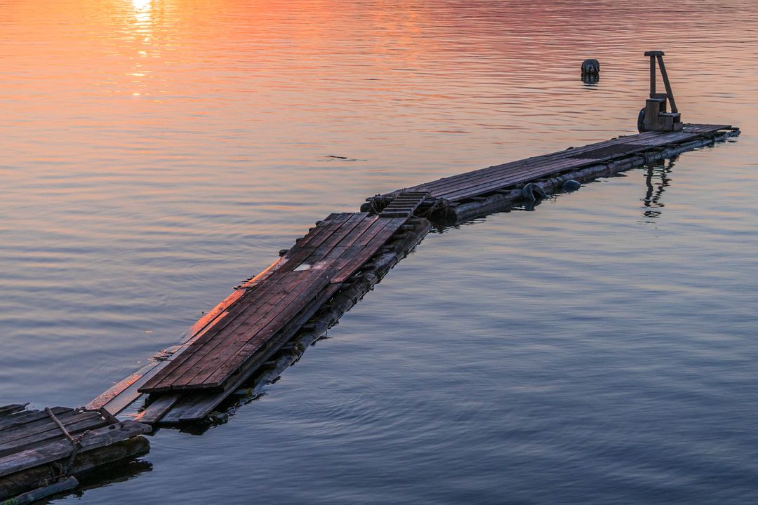 Rustic Wooden Dock Extending Into Calm Water at Sunset - Free Images, Stock Photos and Pictures on Pikwizard.com