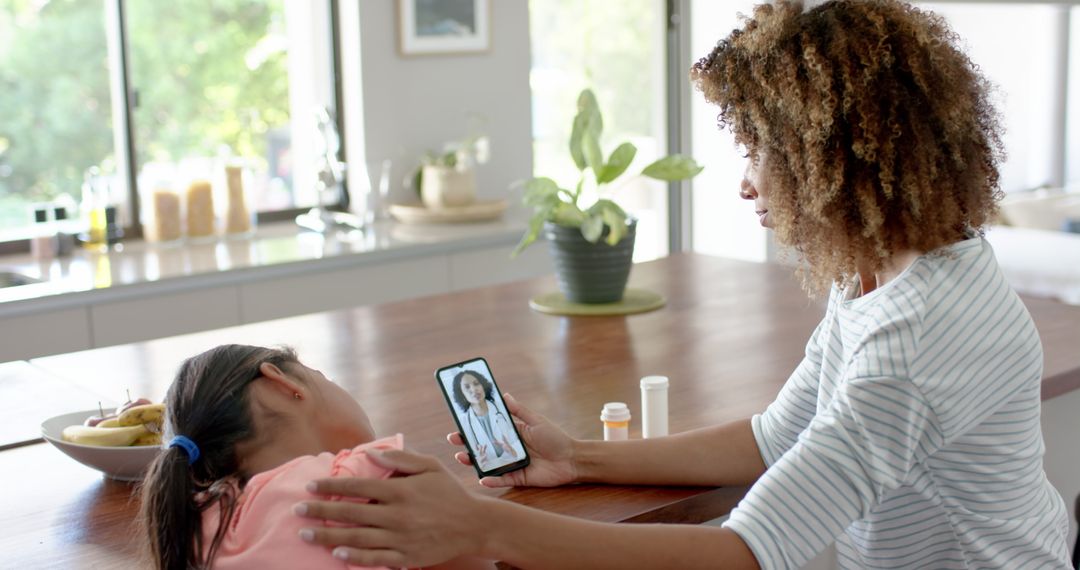 Mother Consulting Doctor via Phone Caring for Unwell Daughter