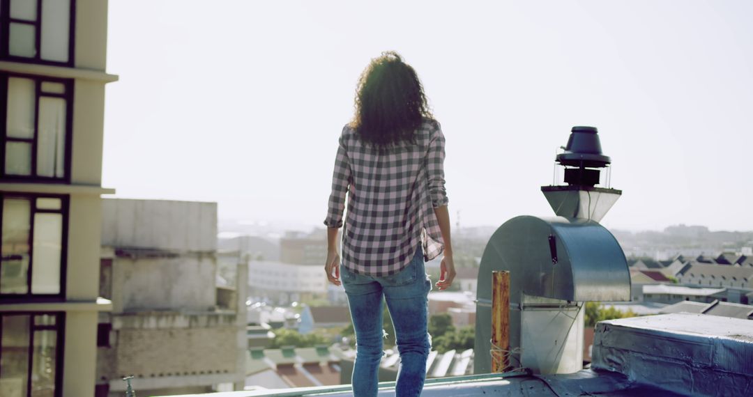 Woman gazing at cityscape from rooftop at sunset - Free Images, Stock Photos and Pictures on Pikwizard.com