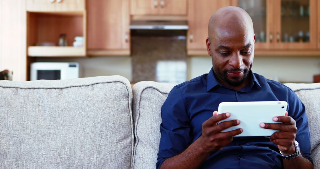 African American Man Relaxing on Couch with Tablet - Free Images, Stock Photos and Pictures on Pikwizard.com