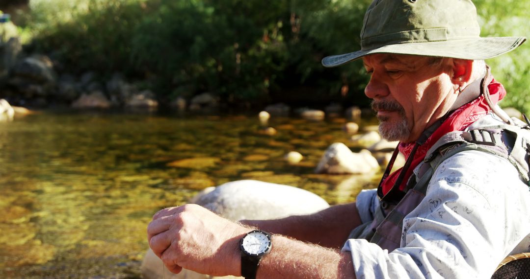 Fly Fisherman Prepares Rod in Sunny Outdoor Setting - Free Images, Stock Photos and Pictures on Pikwizard.com