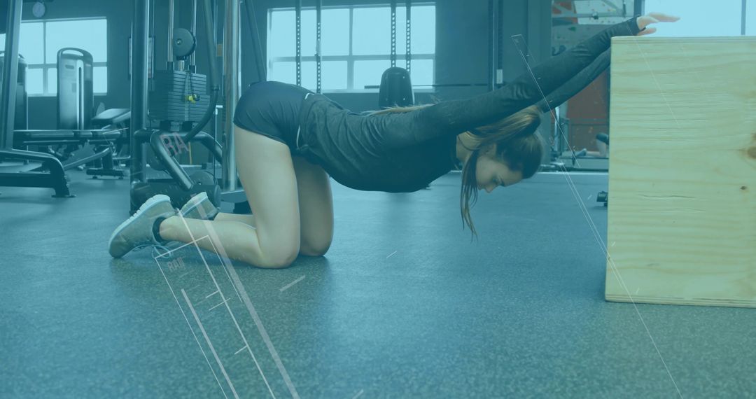 Fitness Enthusiast Stretching on Gym Floor Next to Equipment