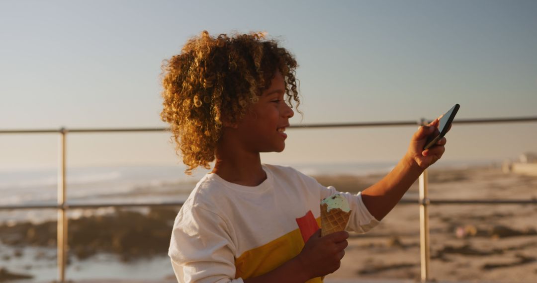 Smiling Child Enjoying Ice Cream and Taking Selfie at the Beach - Free Images, Stock Photos and Pictures on Pikwizard.com