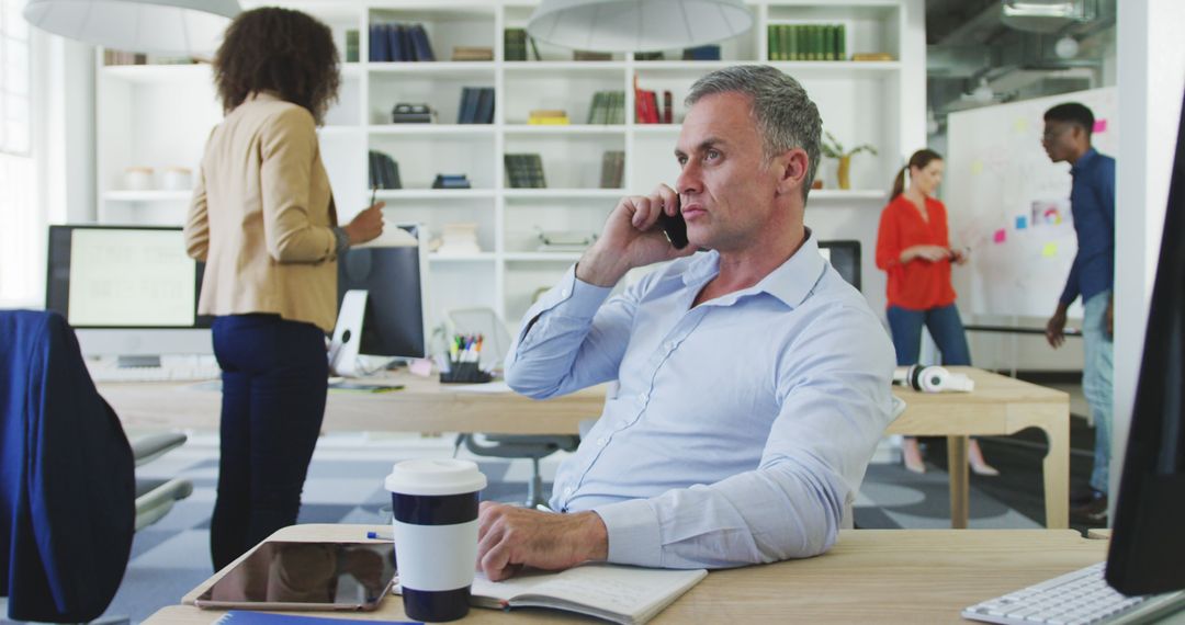 Focused Businessman Taking Phone Call in Modern Office - Free Images, Stock Photos and Pictures on Pikwizard.com