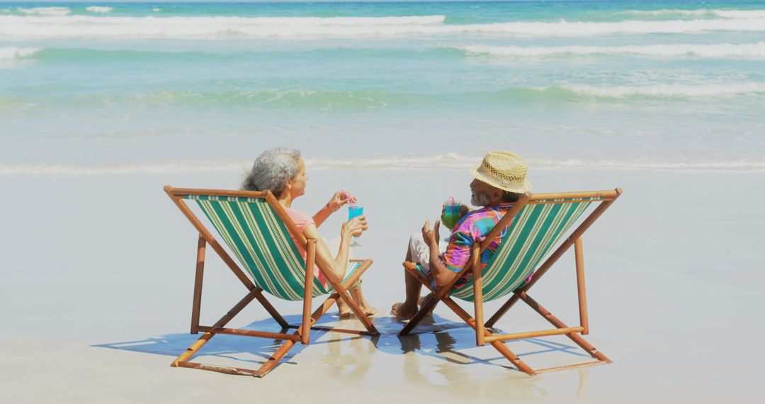 Senior Couple Relaxing on Beach With Drinks