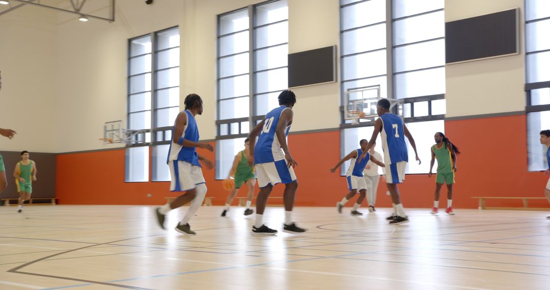 Competitive Basketball Match with Focused Athletes in Modern Gymnasium