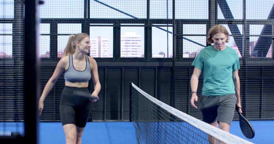 Friends Walking on Paddle Court with Rackets Displaying Sportsmanship