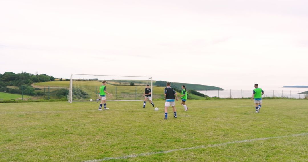 Young Male Soccer Players Training on Sunny Field with Ocean View