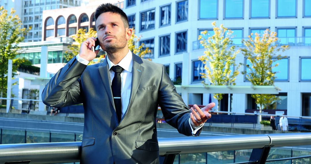 Confident Businessman in Gray Suit Talking on Phone Outdoors - Free Images, Stock Photos and Pictures on Pikwizard.com