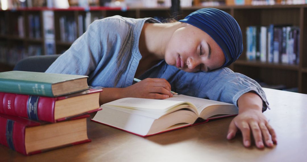 Tired Student Asleep on Books in Library - Free Images, Stock Photos and Pictures on Pikwizard.com