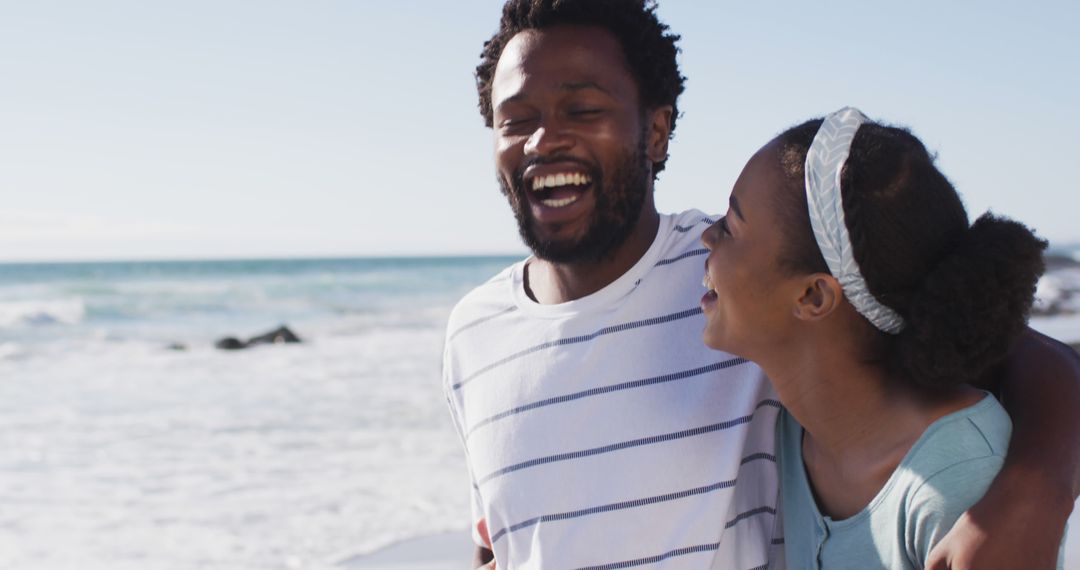 African american couple smiling, embracing and walking on the beach - Free Images, Stock Photos and Pictures on Pikwizard.com