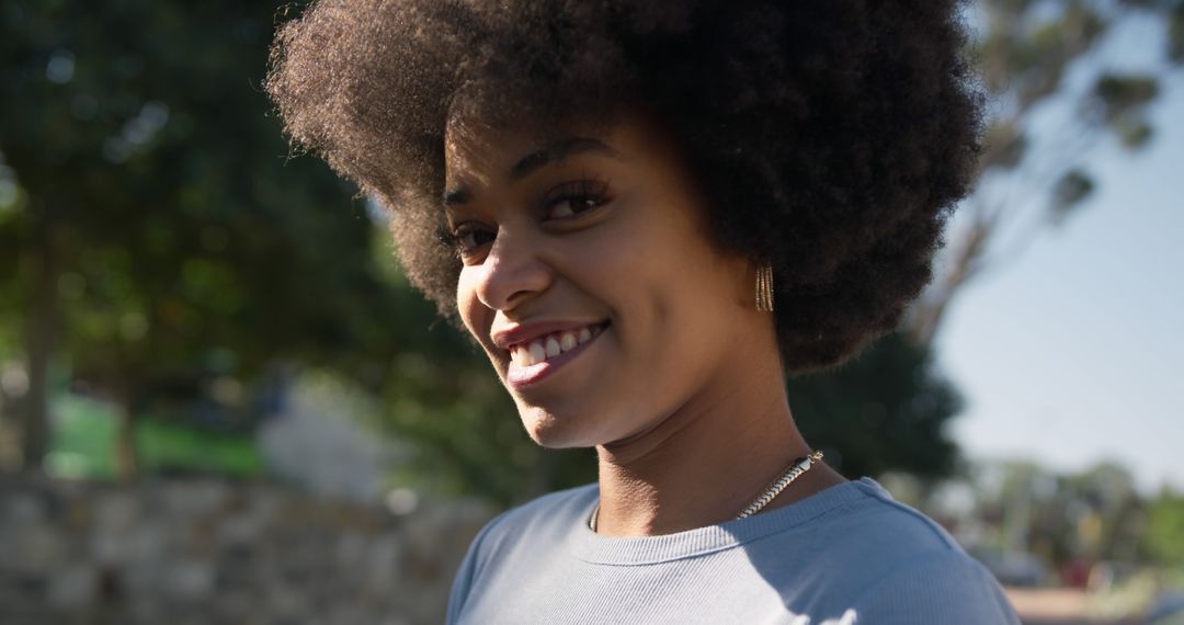 Smiling African American Woman with Afro Hairstyle Outdoors - Free Images, Stock Photos and Pictures on Pikwizard.com