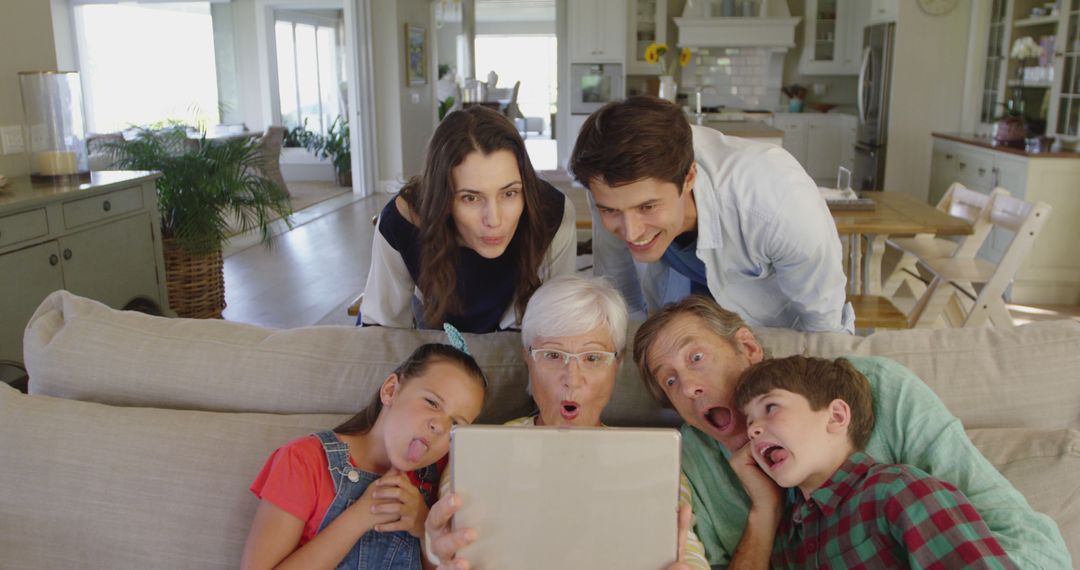 Silly Family Watching Tablet Together in Living Room - Free Images, Stock Photos and Pictures on Pikwizard.com