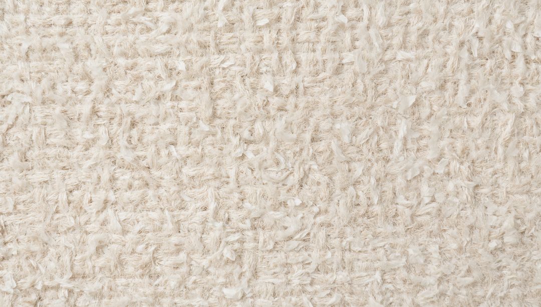 Beige shaggy textile revealing looped weave and fluffy yarn tufts for soft neutral texture