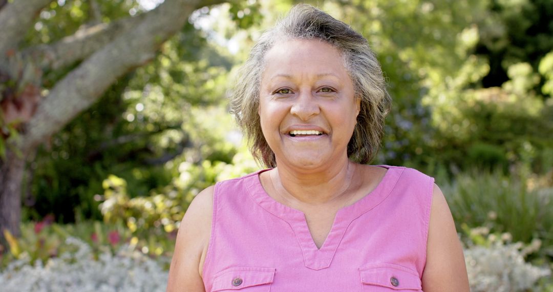 Senior Woman Smiling in Lush Garden Setting Sunny Day