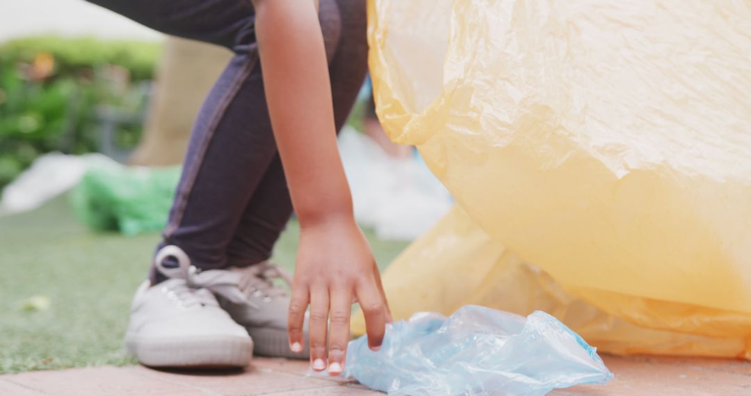 Person Picking Up Plastic Trash in an Outdoor Setting - Free Images, Stock Photos and Pictures on Pikwizard.com