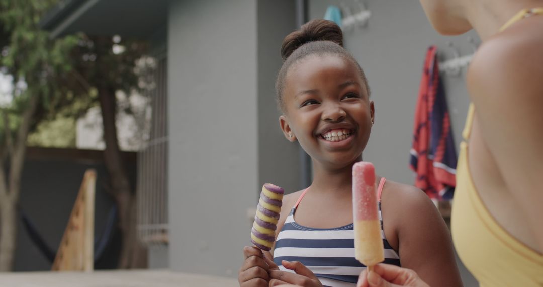 Young African American Girl Smiling with Mother Enjoying Ice Pops Outside - Free Images, Stock Photos and Pictures on Pikwizard.com