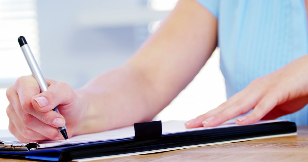 Person Holding Pen Writing on Clipboard at Desk - Free Images, Stock Photos and Pictures on Pikwizard.com