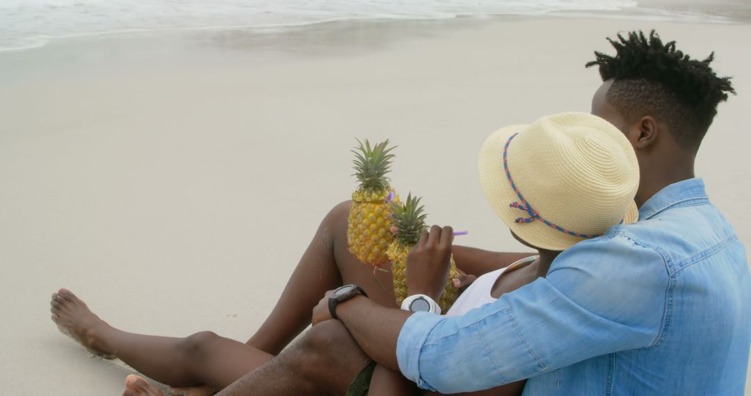 Relaxed Couple Enjoying Pineapple Juice on Beach