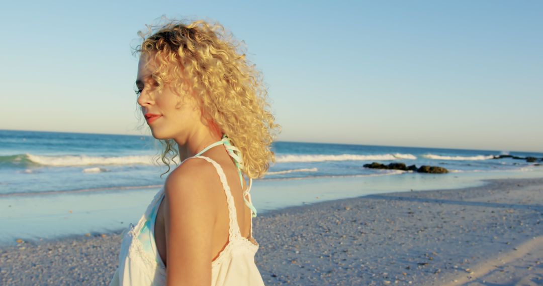 Woman with Curly Hair Enjoying Serene Beach Sunset - Free Images, Stock Photos and Pictures on Pikwizard.com