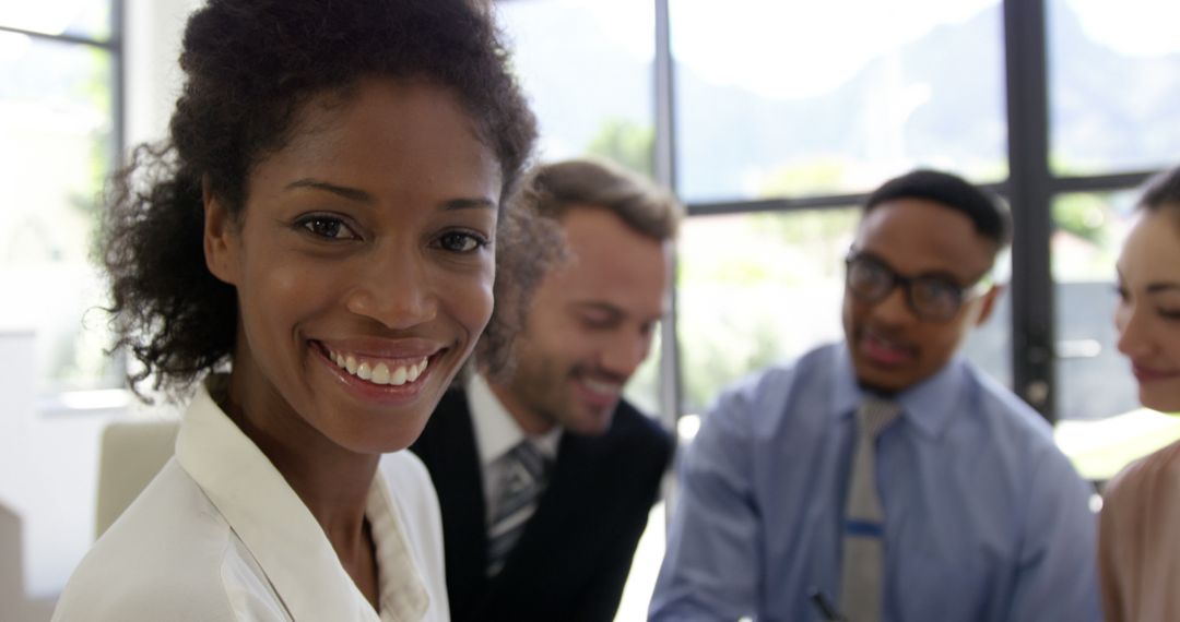 Smiling Businesswoman with Colleagues in a Bright Office - Free Images, Stock Photos and Pictures on Pikwizard.com